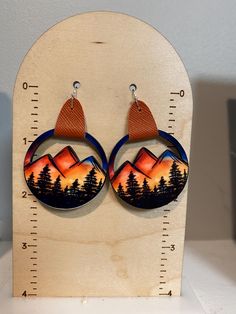 Look at these adorable earrings! These earrings are made using sublimation ink - no vinyl is used.  The mountain design is heat pressed on one side of the precut wood and is permanent.   The connector is made of faux leather. The earrings have an approximate 2.25" drop and are lightweight. The width is approximately 1.5"  Please allow for slight variances as each pair is made to order Please feel free to message me with any questions! Mountain Earrings, Mountain Design, Earrings Summer, Summer Earrings, Mountain Designs, Summer Earring, Sublimation Ink, Leather Earrings, Sign Art