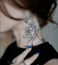 a woman's neck with a flower tattoo on it