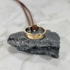 Add two or more items to your cart and enter the code: MOREMETAL during checkout for 15% off of your whole order! This handmade ring necklace is made from brass with .935 Argentium Silver lining the inside of the band, as well as some of the silver being melted onto the outside of the band, as a result, each ring is different. The brass has been crafted and hammered into an incredible ring and tied to a faux leather cord. These comfortable and lightweight necklaces make a perfect gift for any man in your life. The ring is around a quarter of an inch wide and is roughly a size 10 or larger. A complimentary polishing cloth will be included with your order so you can keep your jewelry looking like new. Bronze Bangle, Fire Jewelry, Silver Nose Ring, Anniversary Gift For Him, Brass Bangle, Hammered Brass, Brass Necklace, Argentium Silver, Silver Lining