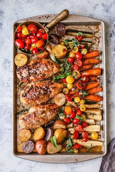 a tray filled with meat, veggies and other food on top of it