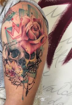 a person with a tattoo on their arm that has a skull and rose on it