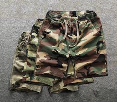 a pair of camouflage shorts with drawstrings on the bottom and side pockets