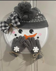 a snowman hat and mittens hanging on a door