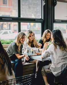 four women sitting at a table eating food