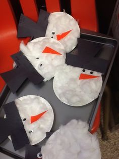 three snowmen made out of toilet paper sitting on top of a pan filled with foam