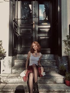 a woman sitting on steps in front of a door