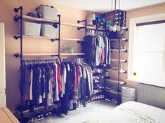 an organized closet with clothes hanging on the wall and shelves full of shoes, hats, and other items