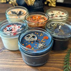 four jars with halloween decorations in them on a table