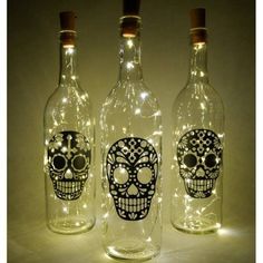 three bottles with lights in them that have skulls on them