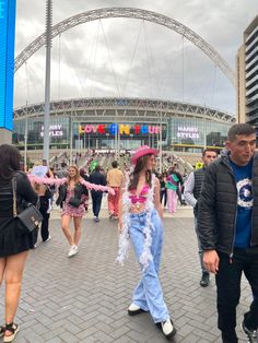 some people are walking around in front of a stadium