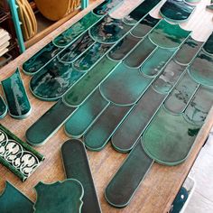 several pieces of green glass sitting on top of a wooden table next to other items