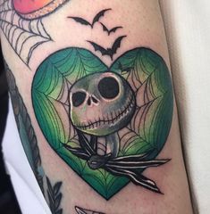 a skull in a heart tattoo on the arm