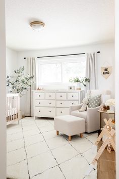 a baby's room with white furniture and rugs on the floor in front of a window