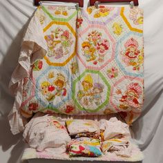 an old fashioned baby crib is covered with quilts