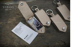 three tan leather key chains with two photos attached to them and a card in the middle