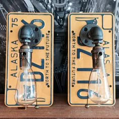 two light bulbs sitting on top of a wooden shelf next to each other in front of a poster