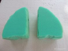 two pieces of green cake sitting on top of a white tablecloth next to each other