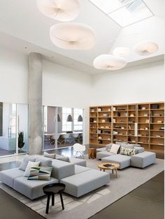 a living room filled with furniture and lots of bookshelves on the wall next to each other