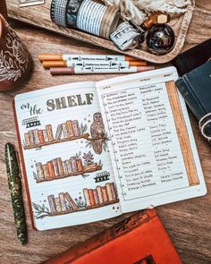 an open book on top of a wooden table next to some books and other items