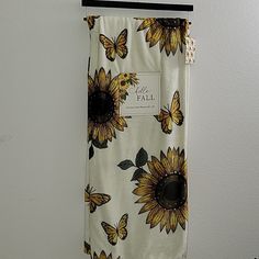 there is a curtain with sunflowers on it hanging from a hook in the wall