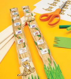 some scissors are laying next to some crafting supplies on a table with yellow paper