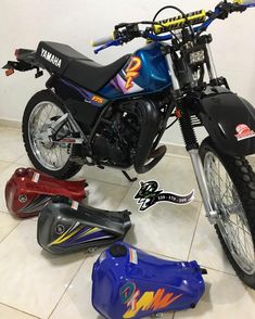 a blue motorcycle parked on top of a tile floor next to other motorbikes