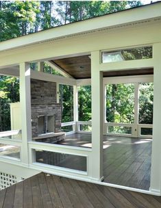 an outdoor living area with wood flooring and glass doors on the side of it