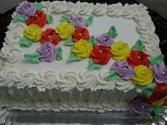 a cake with white frosting and colorful flowers on it