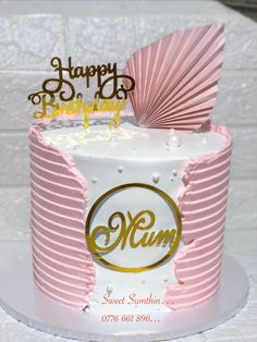 a pink and white birthday cake with the word mum on it