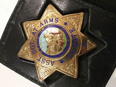 a police badge sitting on top of a black leather bag with the words st marys