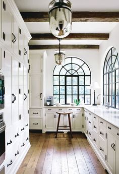 a kitchen with white cabinets and an area rug