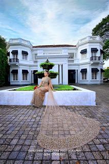 a woman sitting in front of a large white building