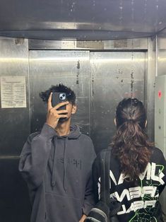 two people standing in front of an elevator