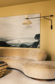 a couch sitting in front of a painting on the wall