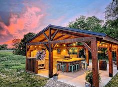 an outdoor kitchen is lit up at dusk