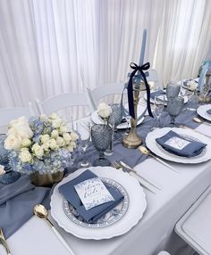 the table is set with blue and white plates, silverware, and napkins