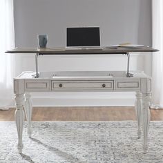 a desk with a laptop on it in front of a white wall and hardwood floors