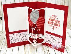 a red and white birthday card with a balloon on the front, and a happy one in the middle