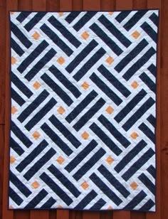 a black and white quilt hanging on a wooden wall