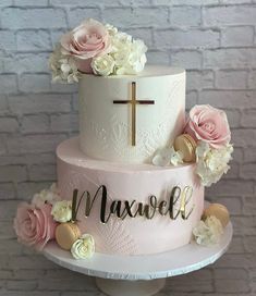 a three tiered cake with flowers and a cross on top