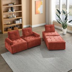 a living room with two red couches and a large rug in front of the window