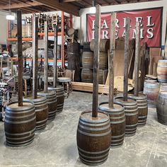 several wooden barrels are lined up in a warehouse