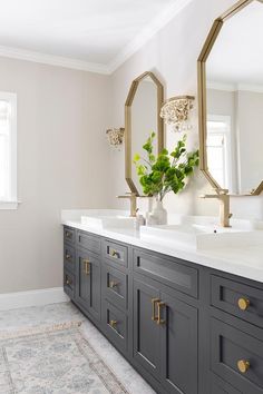 a bathroom with double sinks and large mirrors