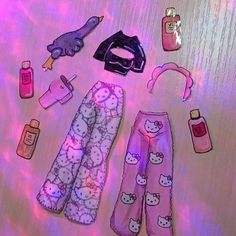 hello kitty pajama pants and other items are on a table with pink lighting