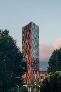 a very tall building with many different colored blocks on it's side and trees in the foreground