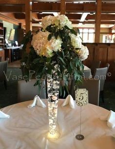 there is a vase with flowers in it on top of a table at a restaurant