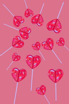 several lollipops are arranged in the shape of hearts on a pink background