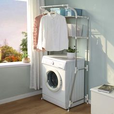 a washer and dryer sitting in front of a window next to a shelf