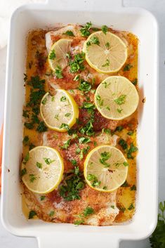 a casserole dish with lemons and parsley