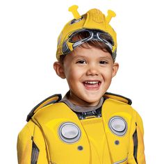 a young boy dressed in a yellow space suit and goggles smiles for the camera